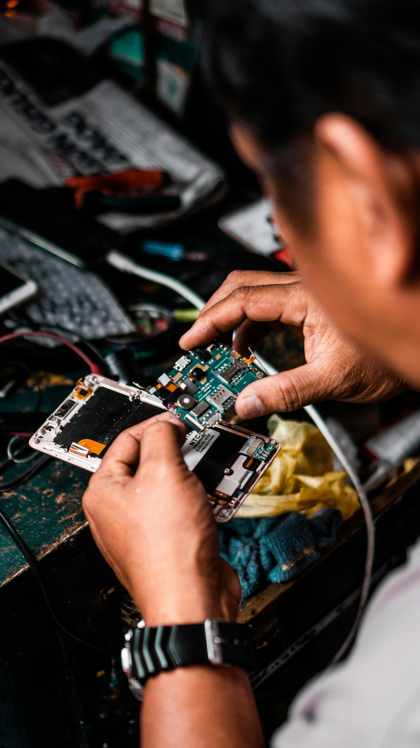 A technician carefully repairing the internal components of a smartphone